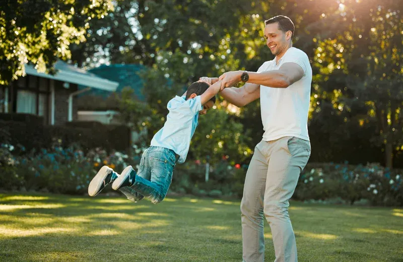 dad and son outside playing in front yard