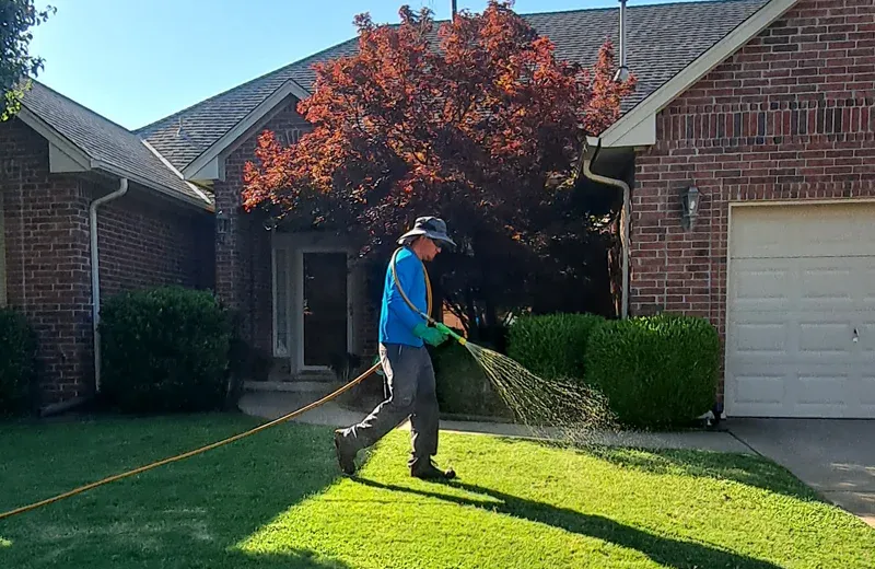 technician spraying lawn for weeds